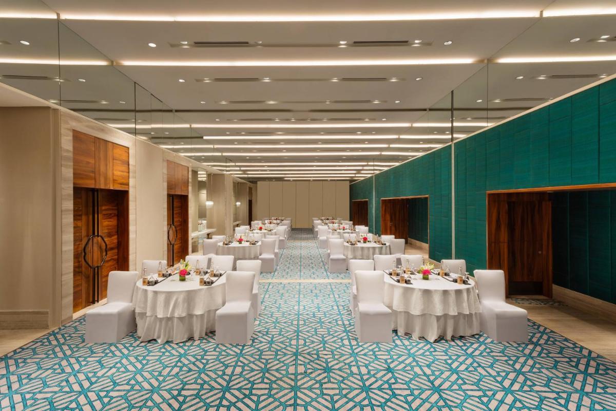 a banquet hall with white tables and white chairs at ITC Kohenur, a Luxury Collection Hotel, Hyderabad in Hyderabad