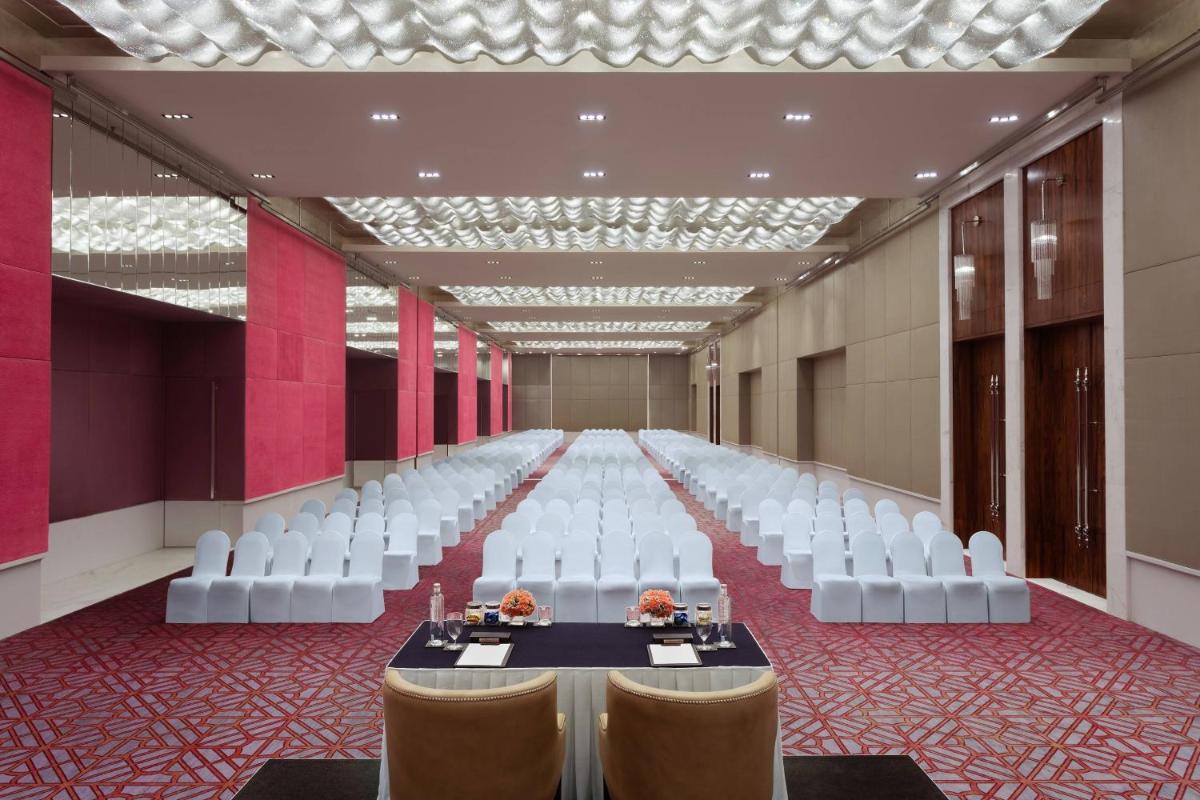 a long banquet hall with white chairs and a table at ITC Kohenur, a Luxury Collection Hotel, Hyderabad in Hyderabad