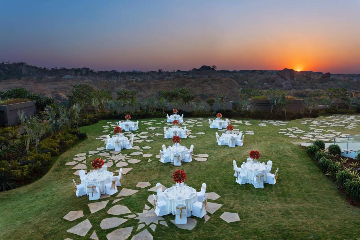 a group of people sitting in a circle on the grass at ITC Kohenur, a Luxury Collection Hotel, Hyderabad in Hyderabad