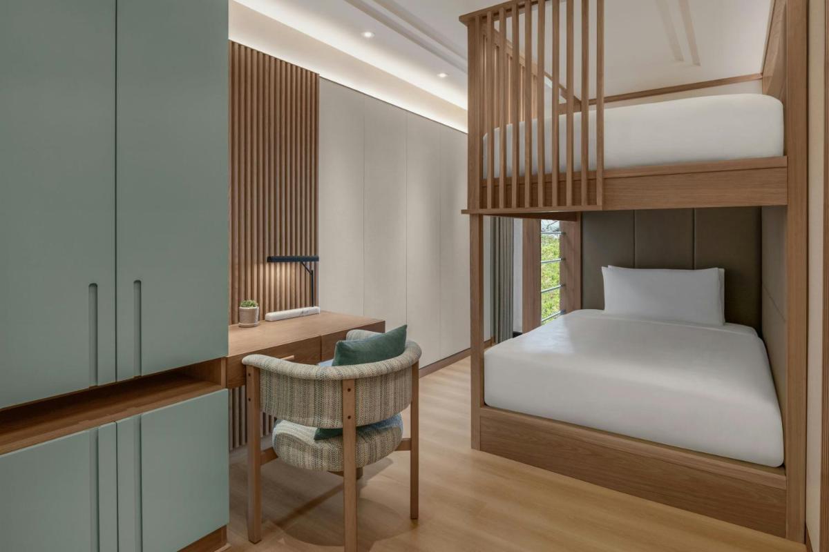 a small bedroom with a bunk bed and a chair at JW Marriott Goa in Vagator a small bedroom with a bunk bed and a chair at JW Marriott Goa in Vagator