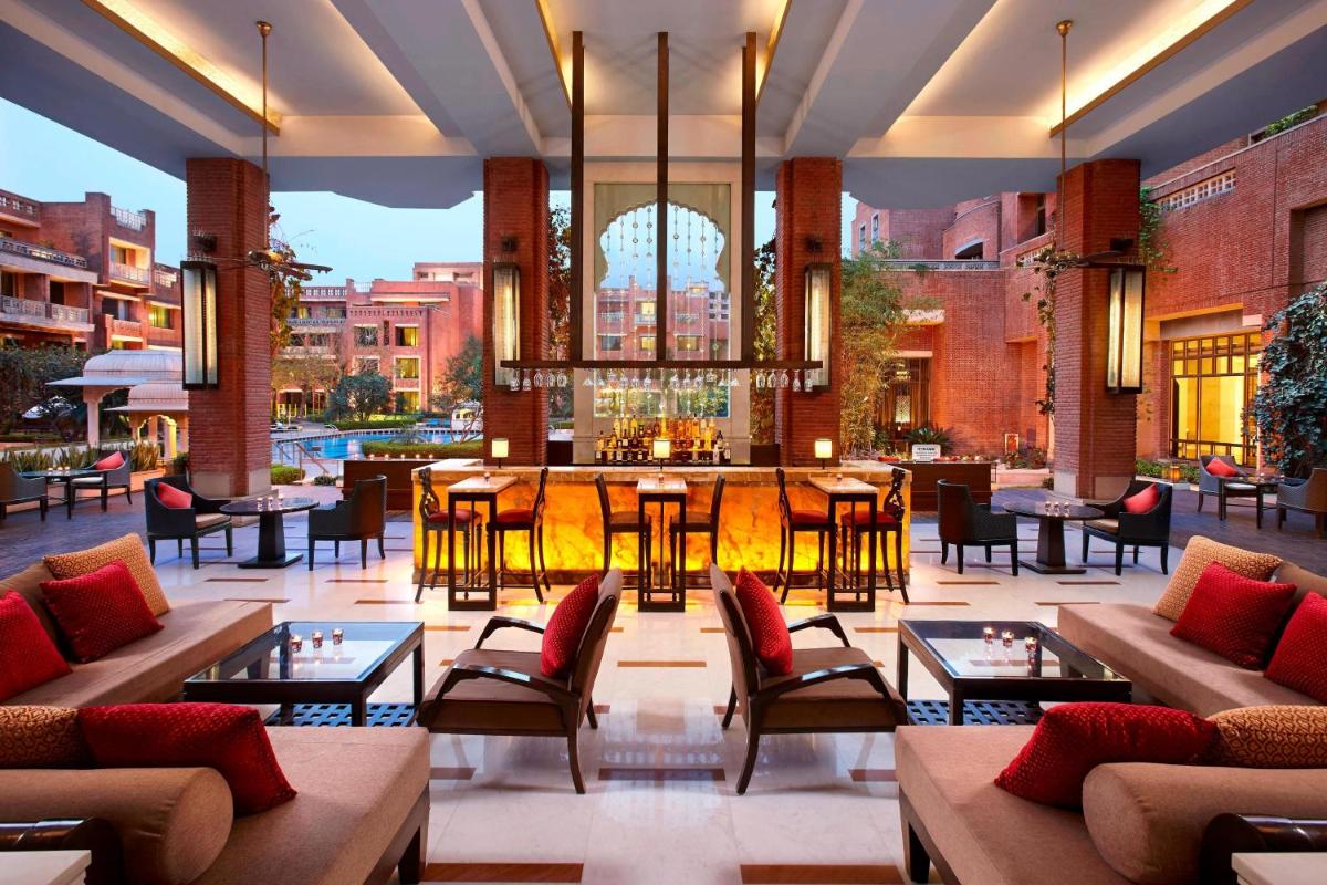 a hotel lobby with tables and chairs and a bar at ITC Rajputana, a Luxury Collection Hotel, Jaipur in Jaipur