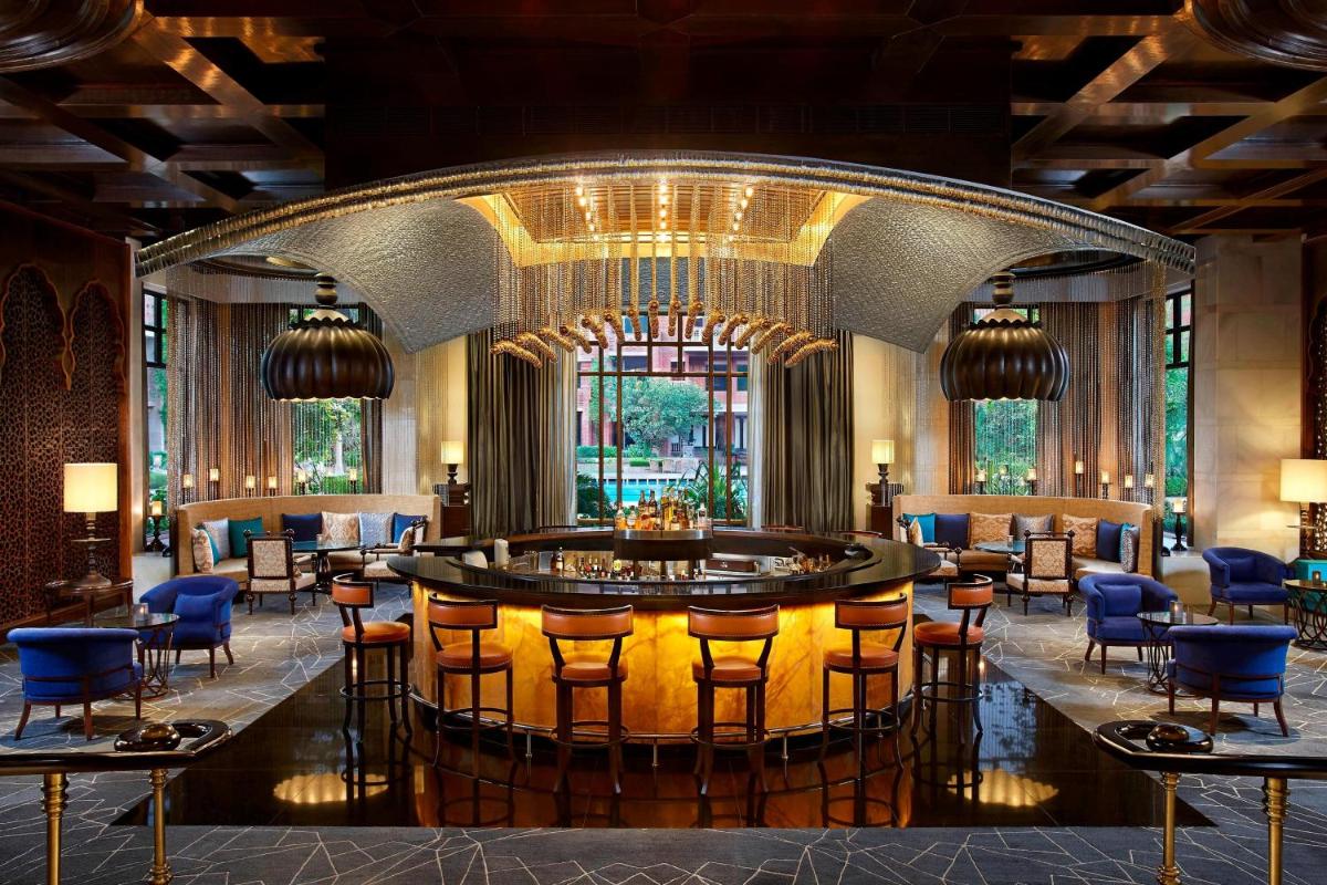 a lobby with a bar with chairs and tables at ITC Rajputana, a Luxury Collection Hotel, Jaipur in Jaipur