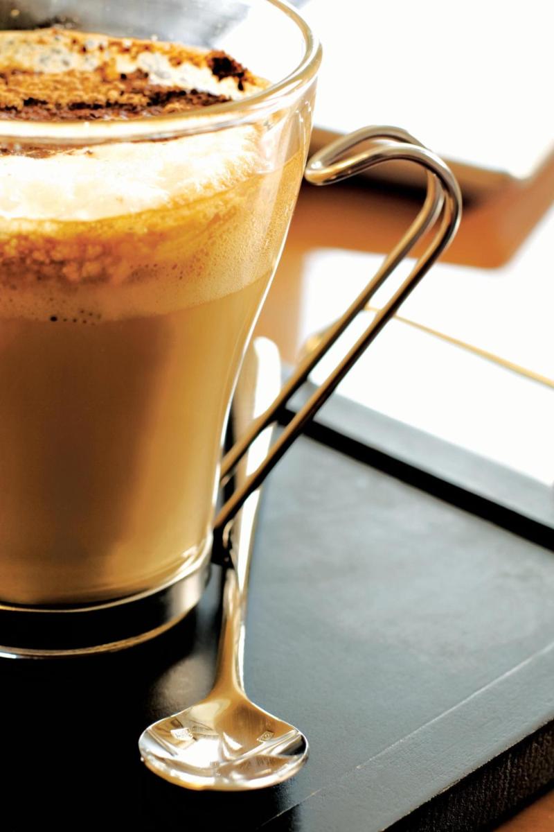 a cup of coffee with a piece of cake in it at Hyderabad Marriott Hotel & Convention Centre in Hyderabad