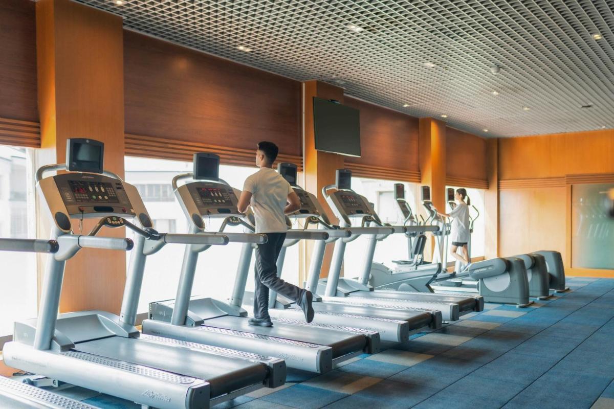 a group of people running on treadmills in a gym at Hyderabad Marriott Hotel & Convention Centre in Hyderabad