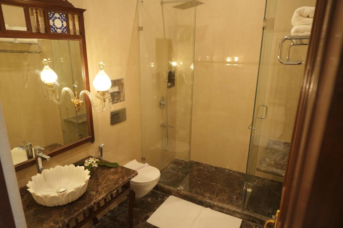 a bathroom with a shower and a toilet and a sink at The Grand Imperial - Heritage Hotel in Agra