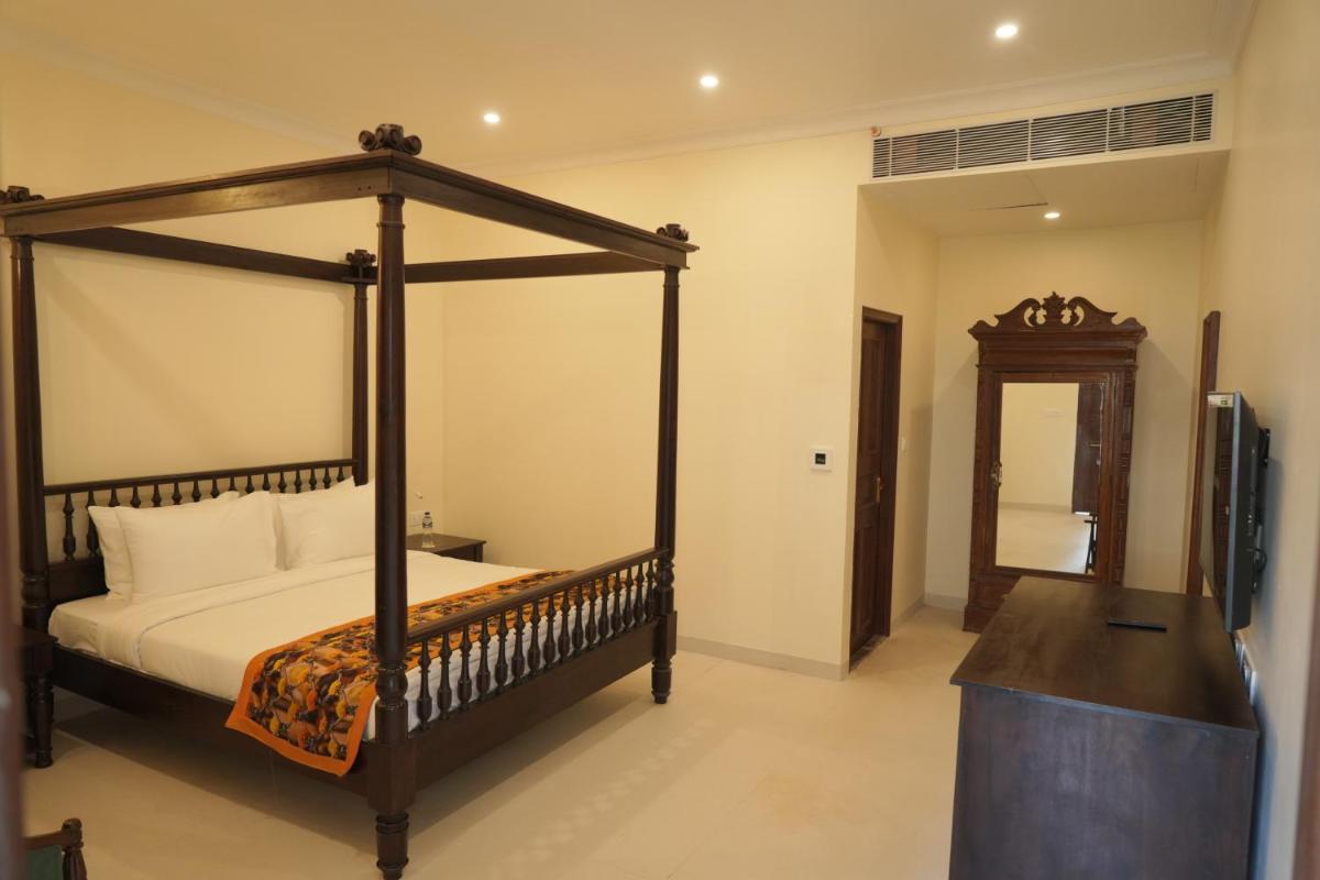 a bedroom with a canopy bed and a television at The Grand Imperial - Heritage Hotel in Agra