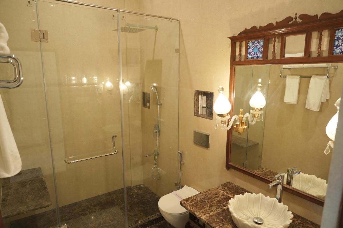 a bathroom with a glass shower and a toilet at The Grand Imperial - Heritage Hotel in Agra
