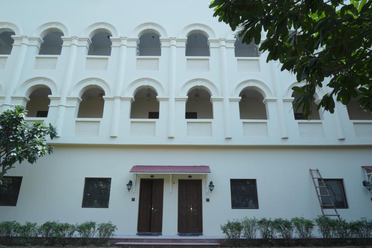 a white building with brown doors and windows at The Grand Imperial - Heritage Hotel in Agra
