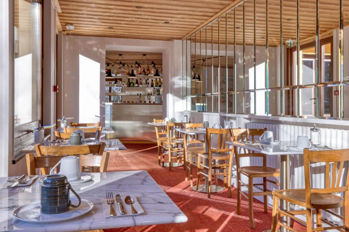 un restaurant avec des tables et des chaises dans une salle dans l'établissement Hôtel Lyret, à Chamonix-Mont-Blanc