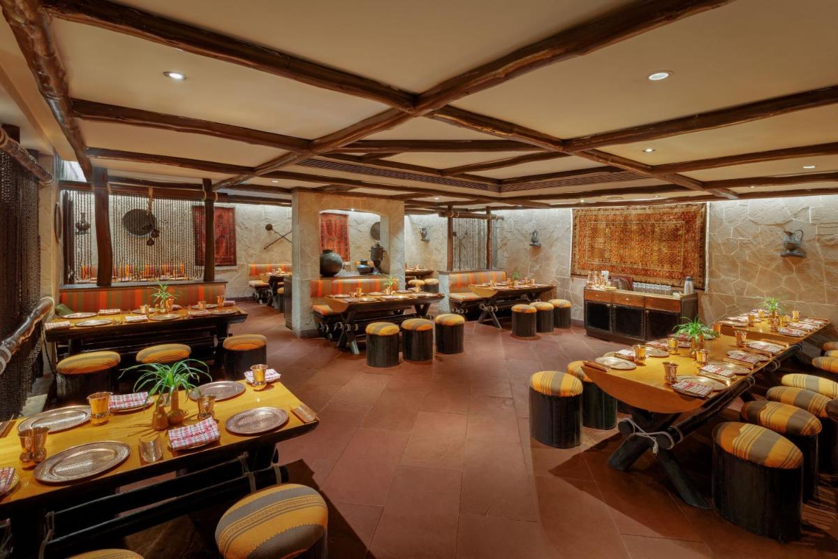 a restaurant with tables and stools in a room at ITC Sonar, a Luxury Collection Hotel, Kolkata in Kolkata
