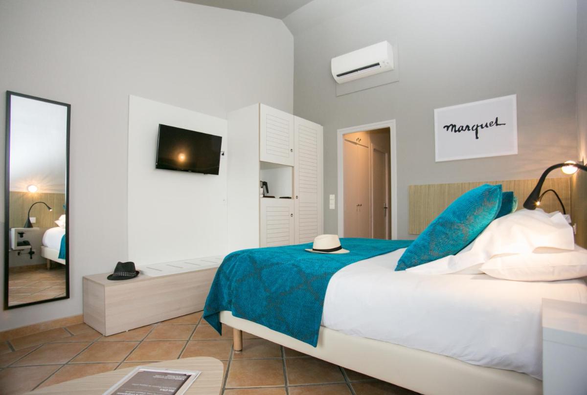 une chambre avec un lit avec des draps bleus et un miroir dans l'établissement Le Relais Des Trois Mas, à Collioure 63 autres photos