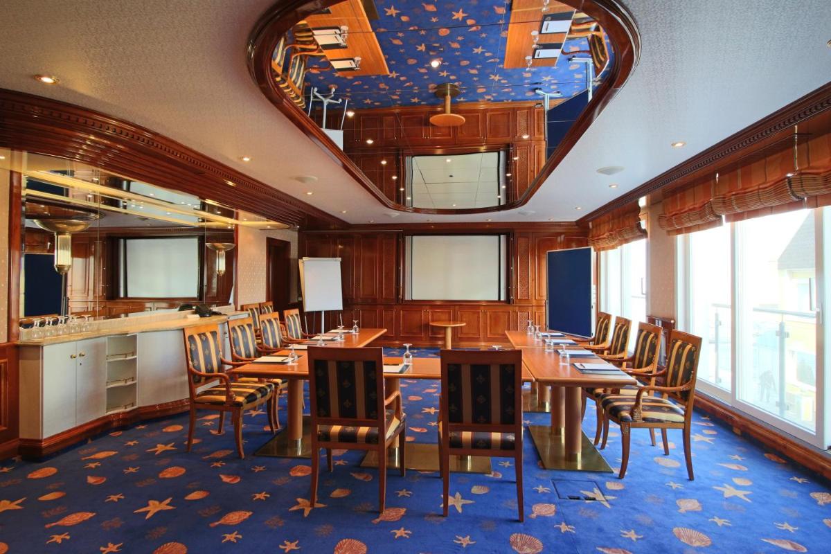 ein Esszimmer mit einem langen Tisch und Stühlen in der Unterkunft Hotel Strandperle in Cuxhaven + 37 Fotos