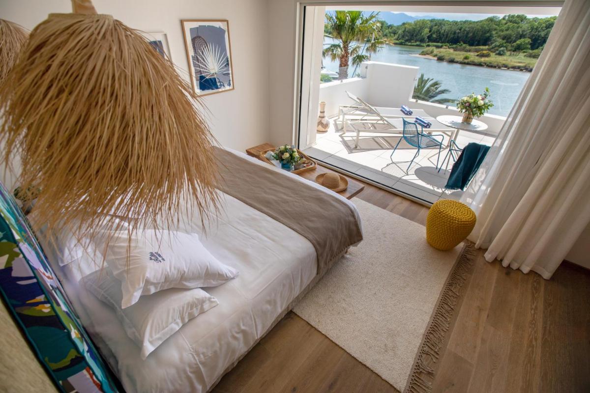 une chambre avec un lit avec une grande fenêtre dans l'établissement Les Bulles de Mer - Hotel & Spa sur la Plage, à Saint-Cyprien