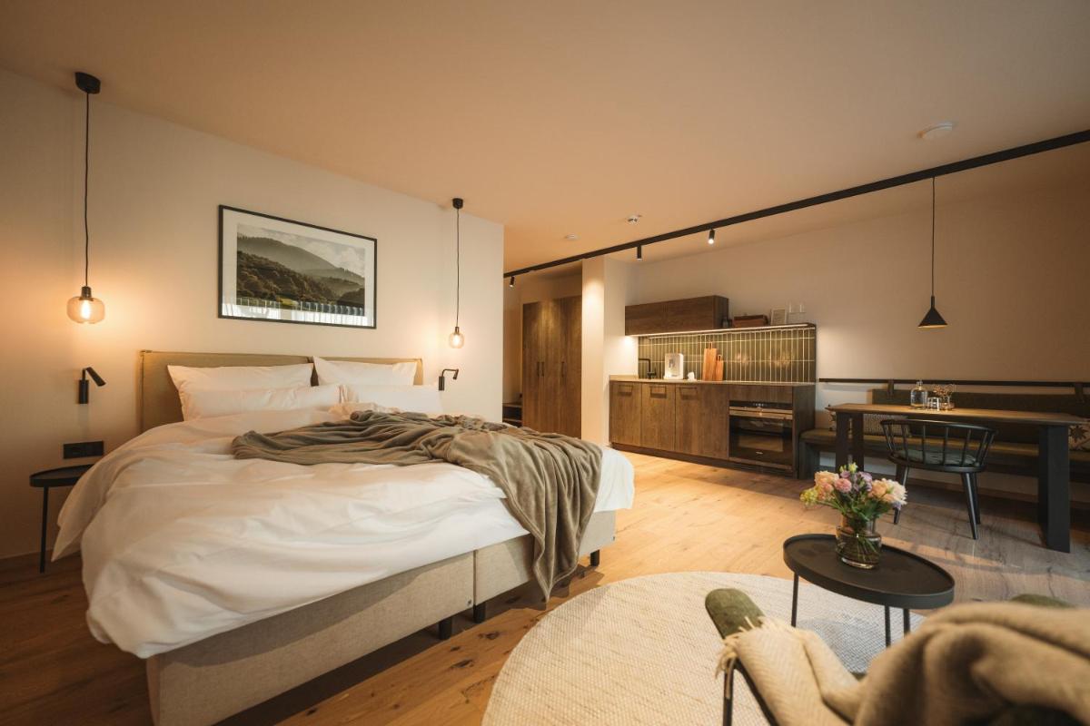 ein Schlafzimmer mit Bett und ein Wohnzimmer in der Unterkunft Agrad Chalets in Aschau im Chiemgau