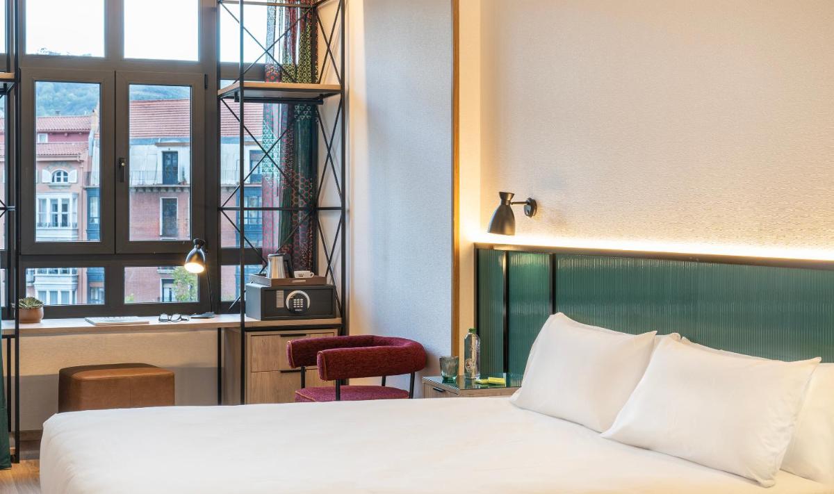 Una habitación de hotel con una cama, un escritorio y una ventana. en Axel Hotel Bilbao - Adults Only, en Bilbao 35 fotos más