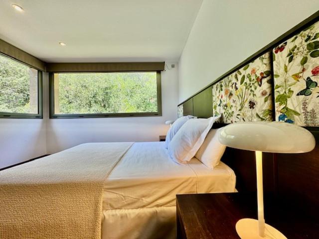 Un dormitorio con una cama grande y dos ventanas. en Hotel Spa La Central - Adults Only, en Maçanet de Cabrenys 43 fotos más