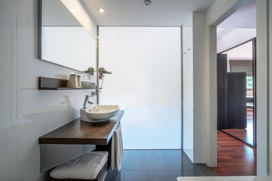 Un baño con un lavabo sobre una mesa de madera. en Hotel Spa La Central - Adults Only, en Maçanet de Cabrenys