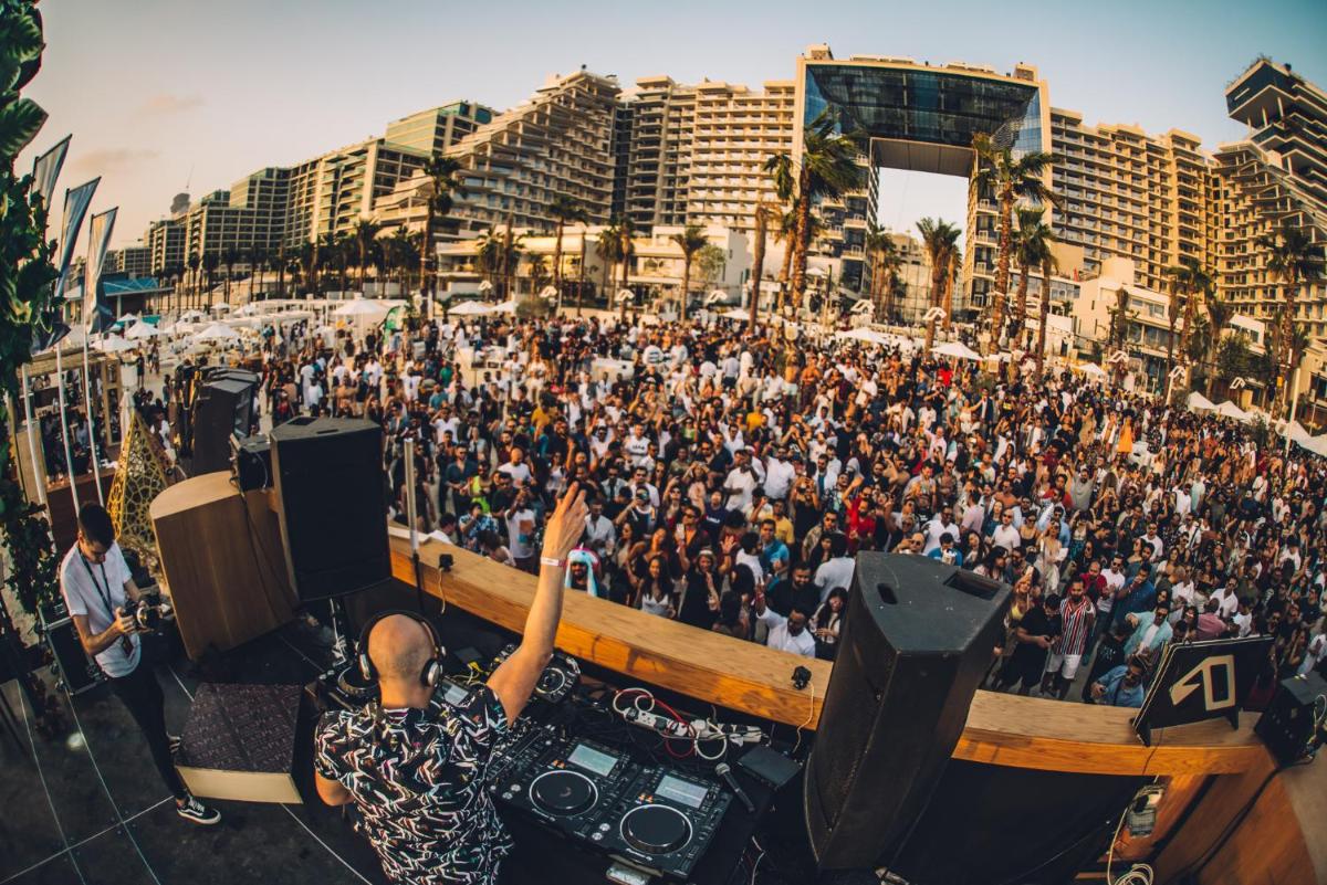 a crowd of people standing in front of a stage at FIVE Palm Jumeirah Dubai in Dubai a crowd of people standing in front of a stage at FIVE Palm Jumeirah Dubai in Dubai