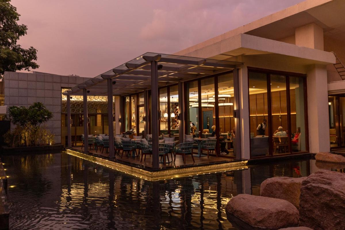 a building with a pool of water in front of it at Hyatt Hyderabad Gachibowli in Hyderabad