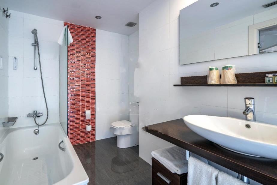 Un baño con lavabo, bañera e inodoro. en Hotel Spa La Central - Adults Only, en Maçanet de Cabrenys