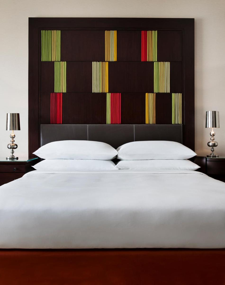 a bedroom with a large bed with a large headboard at JW Marriott Hotel Bengaluru in Bengaluru