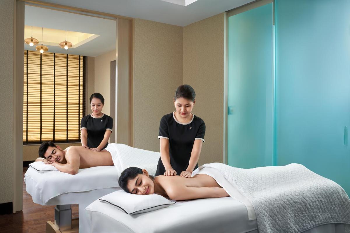 a group of men laying on beds in a room at JW Marriott Hotel Bengaluru in Bengaluru