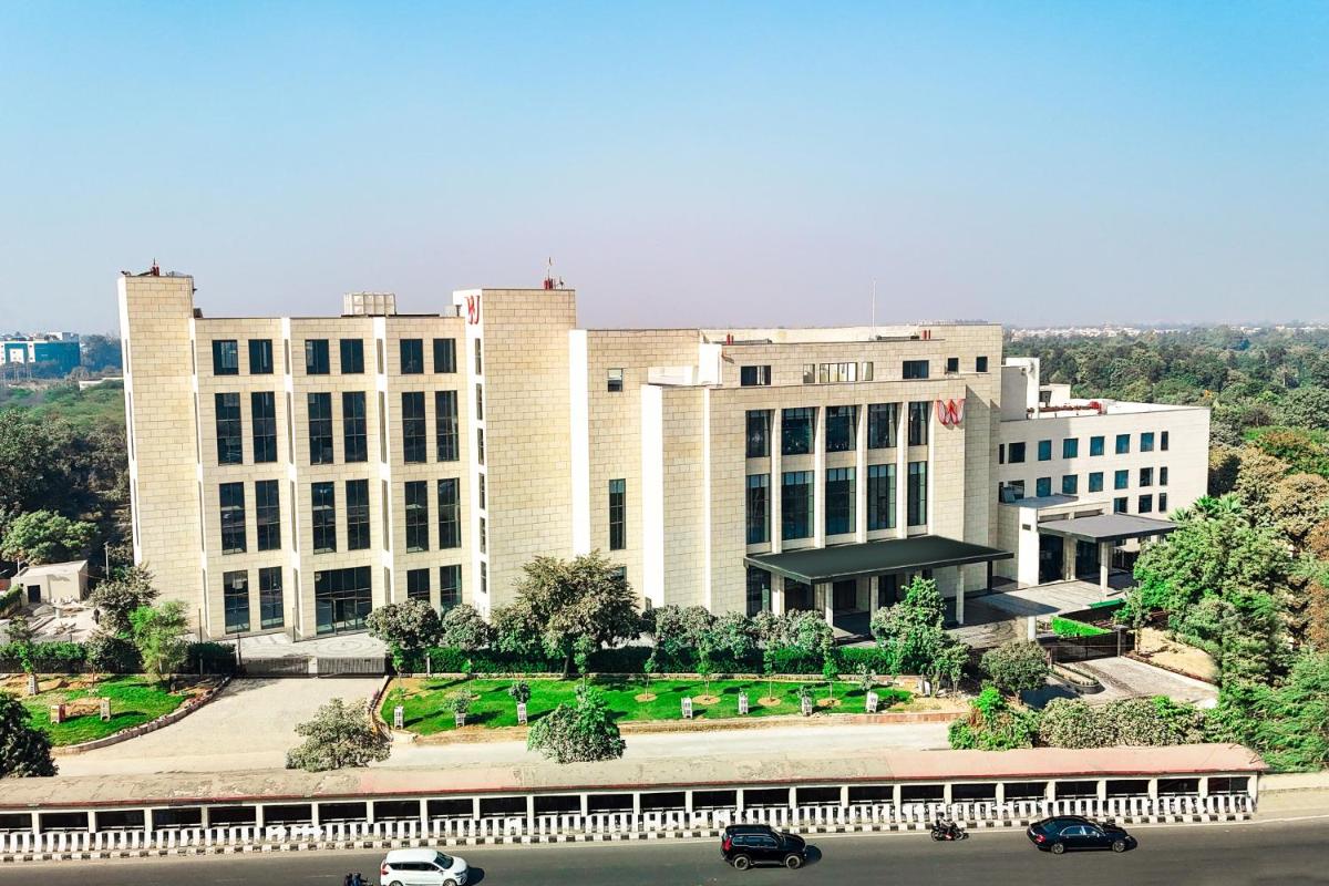 a large white building with cars parked in front of it at Welcomhotel by ITC Hotels, Delhi-Gurugram Highway in New Delhi