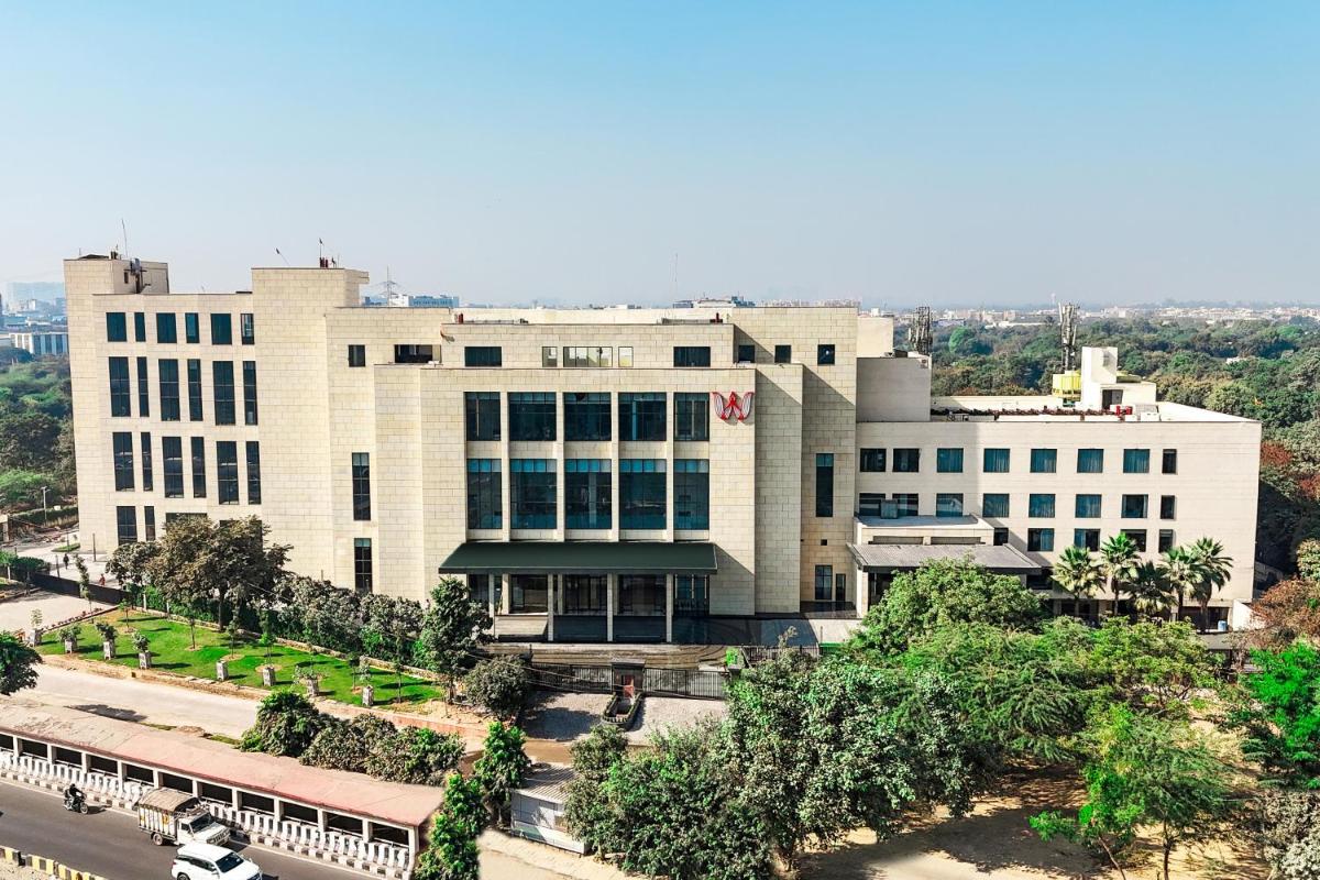 a large white building with trees in front of it at Welcomhotel by ITC Hotels, Delhi-Gurugram Highway in New Delhi