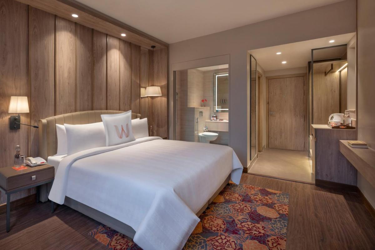 a bedroom with a large white bed and a bathroom at Welcomhotel by ITC Hotels, Delhi-Gurugram Highway in New Delhi