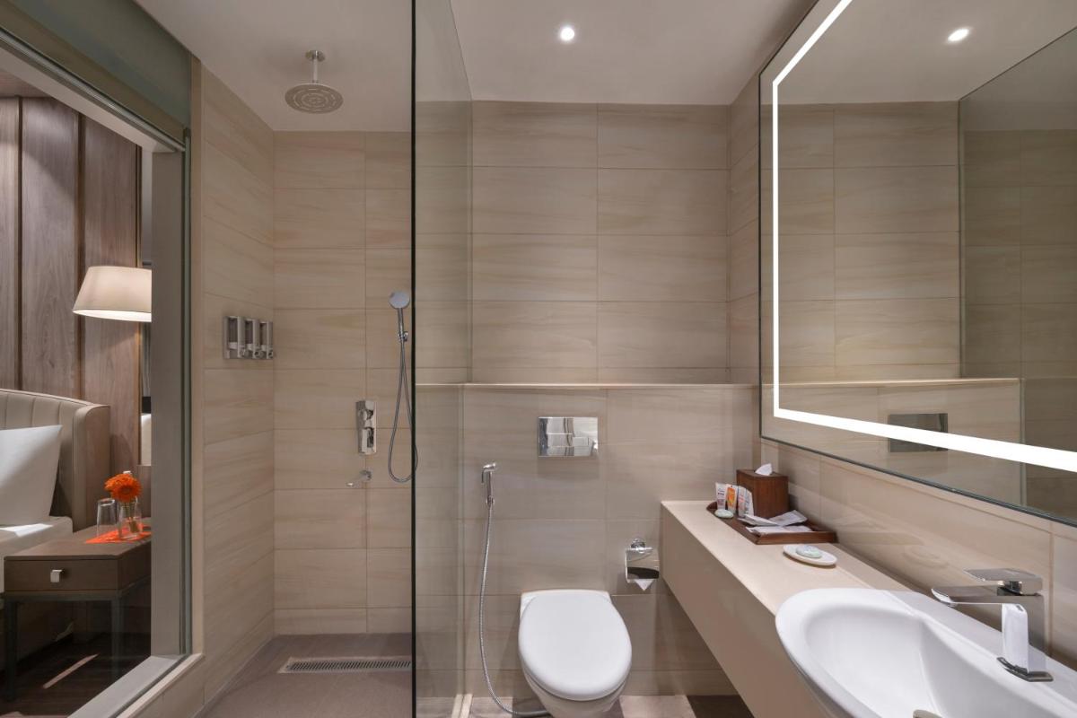a bathroom with a toilet and a sink and a shower at Welcomhotel by ITC Hotels, Delhi-Gurugram Highway in New Delhi a bathroom with a toilet and a sink and a shower at Welcomhotel by ITC Hotels, Delhi-Gurugram Highway in New Delhi
