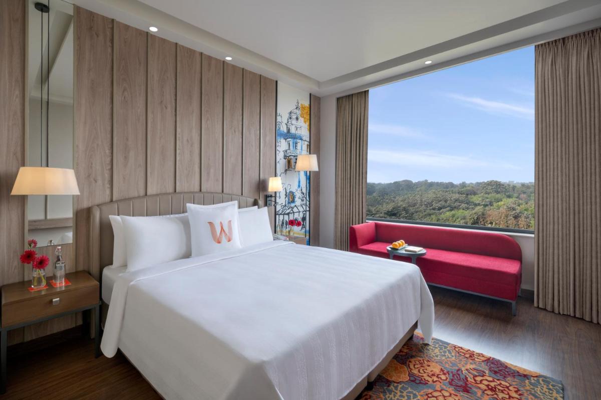 a bedroom with a large white bed and a red couch at Welcomhotel by ITC Hotels, Delhi-Gurugram Highway in New Delhi +24 photos