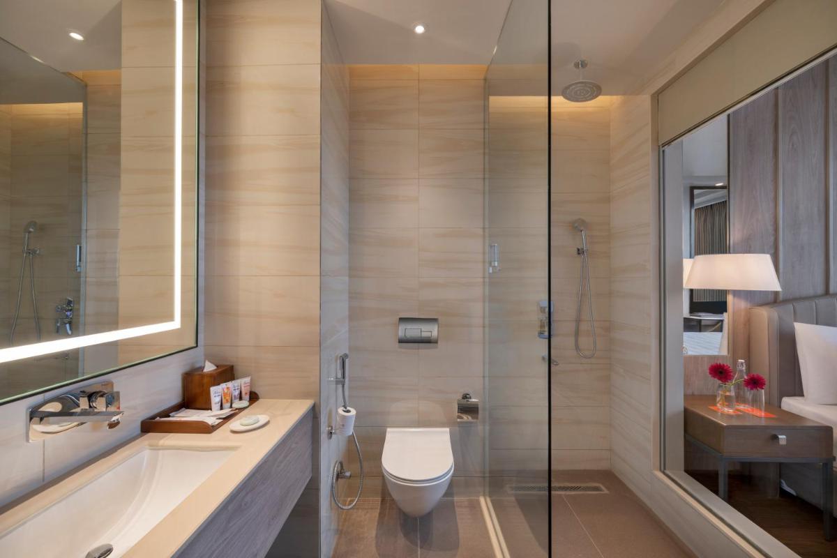 a bathroom with a shower and a toilet and a sink at Welcomhotel by ITC Hotels, Delhi-Gurugram Highway in New Delhi