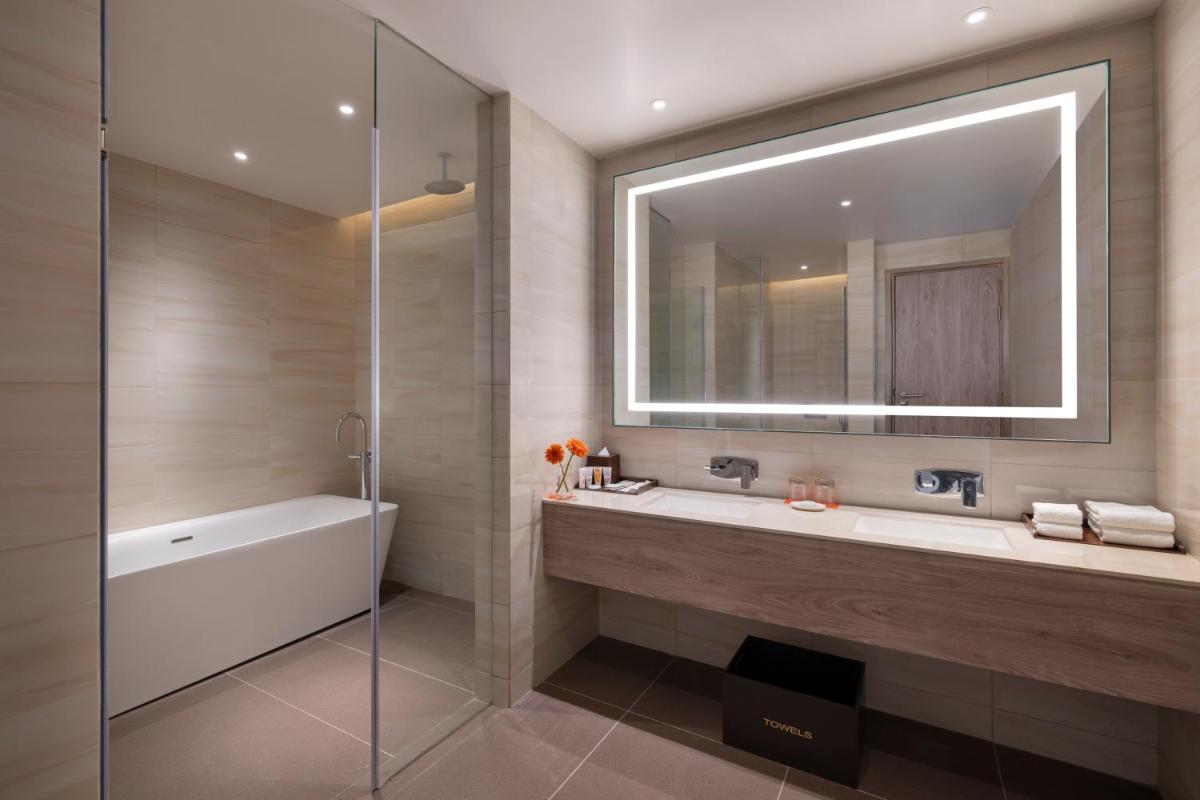 a bathroom with a tub and a sink and a mirror at Welcomhotel by ITC Hotels, Delhi-Gurugram Highway in New Delhi