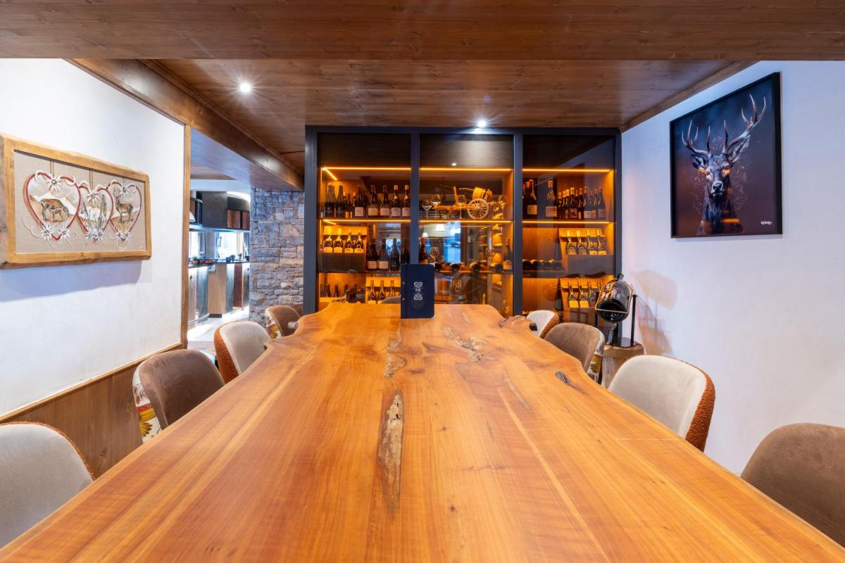 une grande table en bois dans une pièce avec des chaises dans l'établissement Hôtel Macchi Restaurant & Spa, à Châtel 124 autres photos
