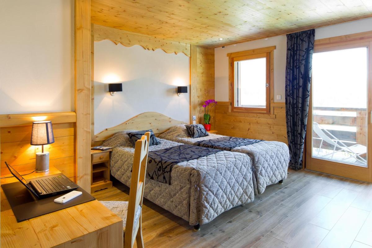 une chambre avec un lit et un bureau avec un ordinateur portable dans l'établissement Logis Hotel & Spa Beau-Site, à Saint-Jean-de-Sixt