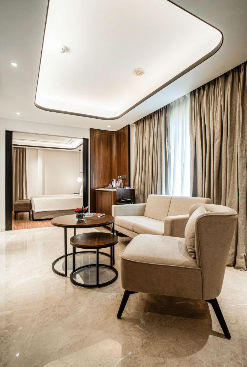 a living room with two couches and a table at Radisson Blu Hotel Ahmedabad in Ahmedabad