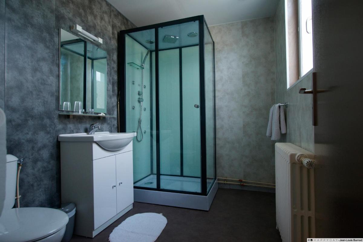 une salle de bain avec une douche en verre et un lavabo dans l'établissement Hôtel La Tente Verte, à Loon-Plage