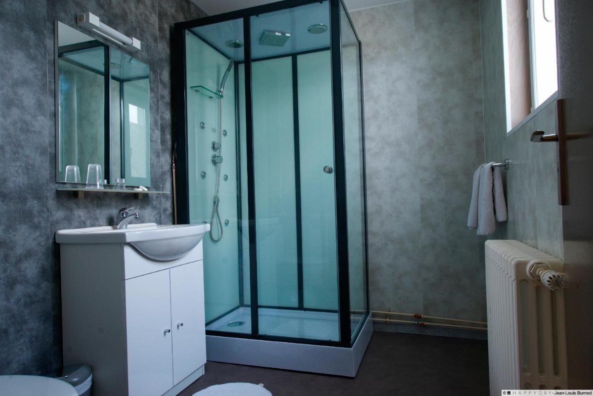 une salle de bain avec une douche en verre et un lavabo dans l'établissement Hôtel La Tente Verte, à Loon-Plage