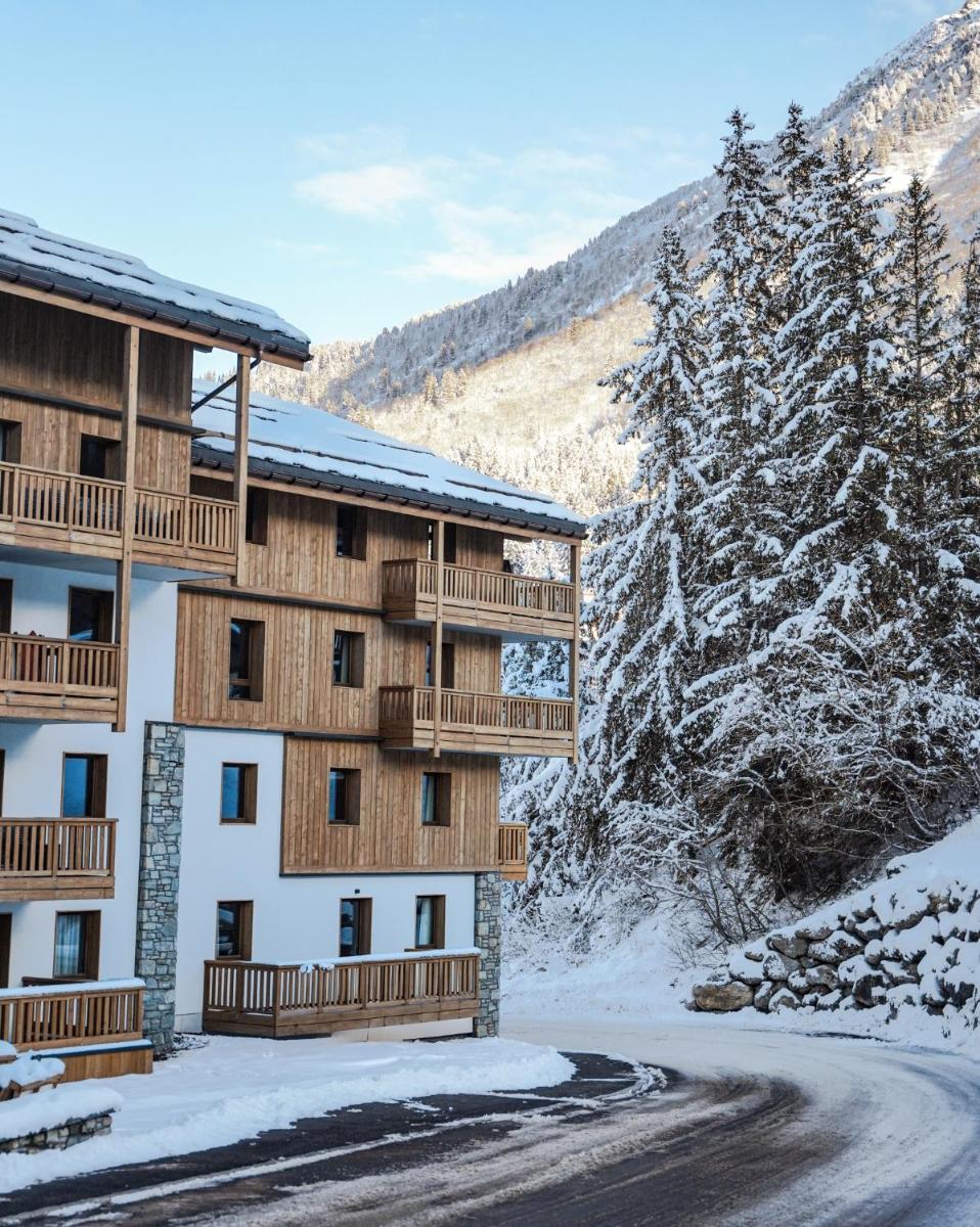 un bâtiment avec de la neige au sol à côté d'une route dans l'établissement Résidence l'Ecrin d'Argent by My Mountain Resort, à Valmorel