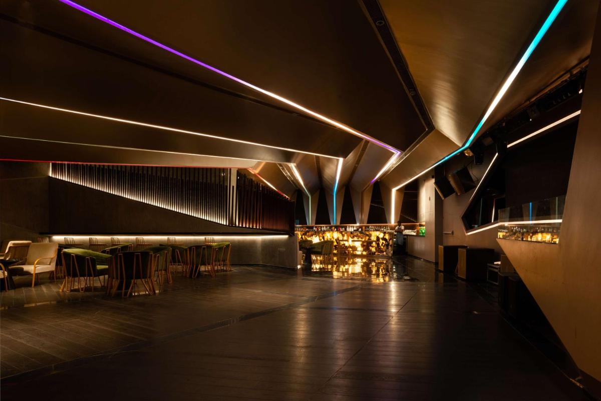 a lobby with a bar with chairs and lights at Radisson Blu Bengaluru Outer Ring Road in Bengaluru