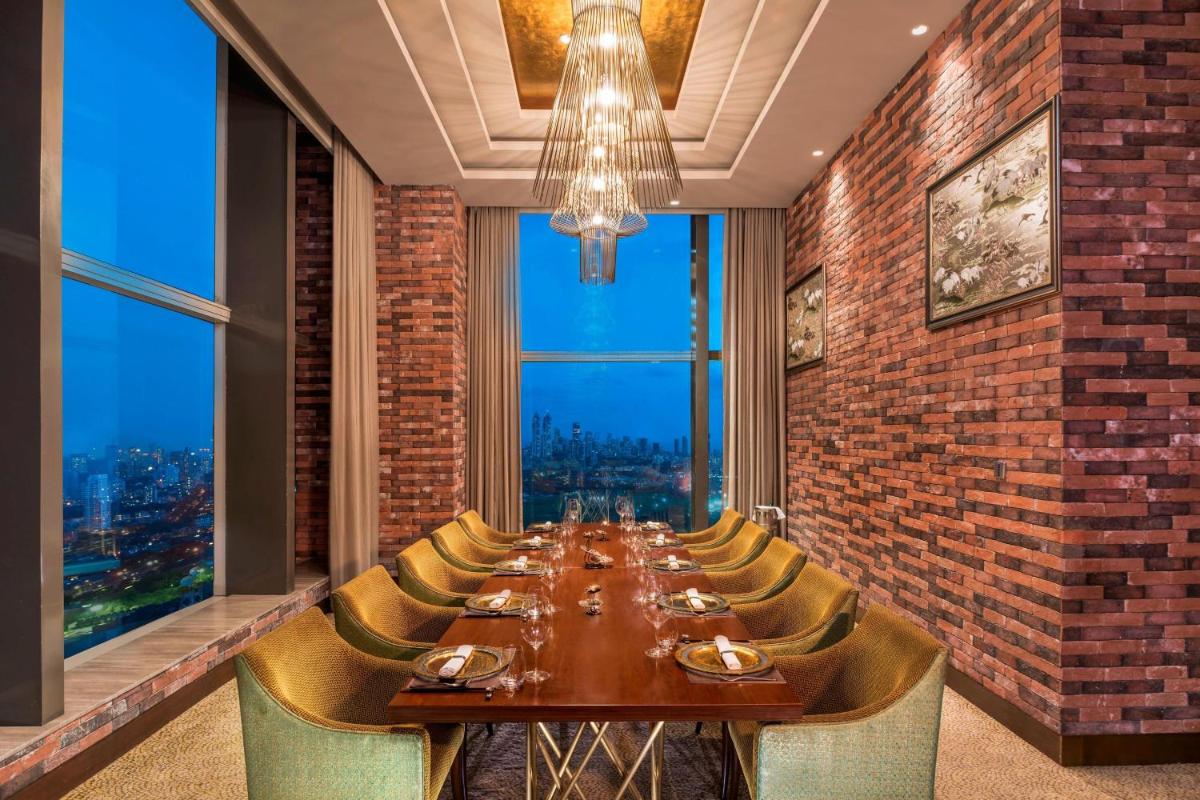 a long dining room with a long table and chairs at The St. Regis Mumbai in Mumbai