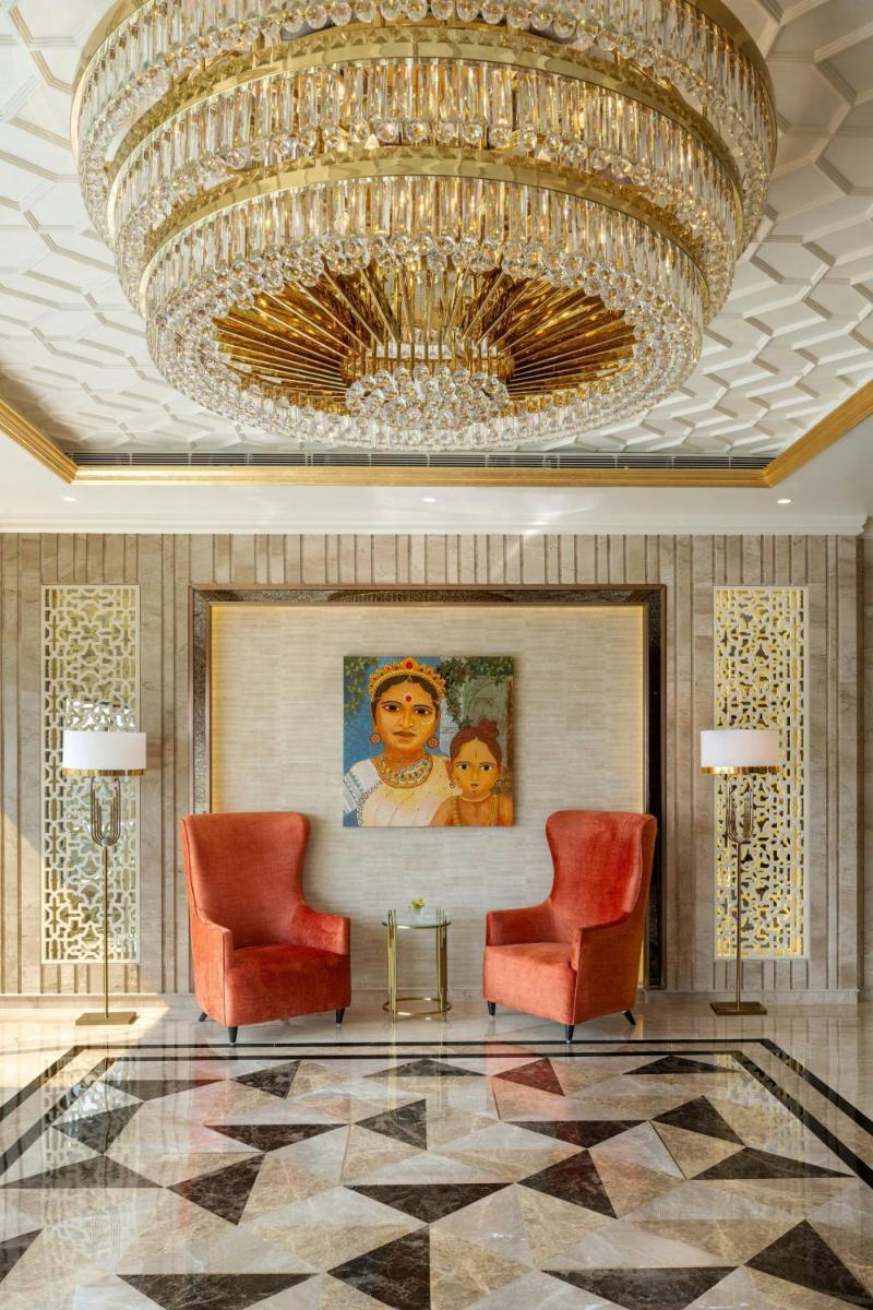 a lobby with two chairs and a large chandelier at The St. Regis Mumbai in Mumbai