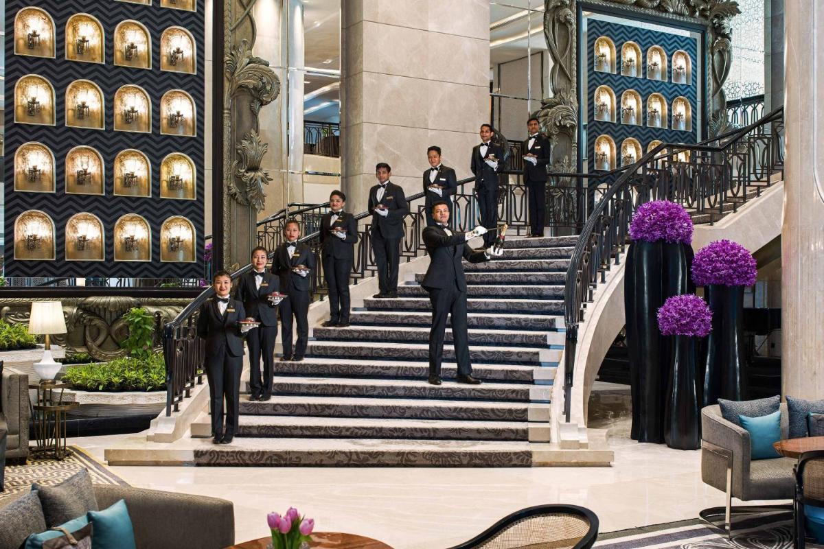 a group of men in suits walking down stairs at The St. Regis Mumbai in Mumbai