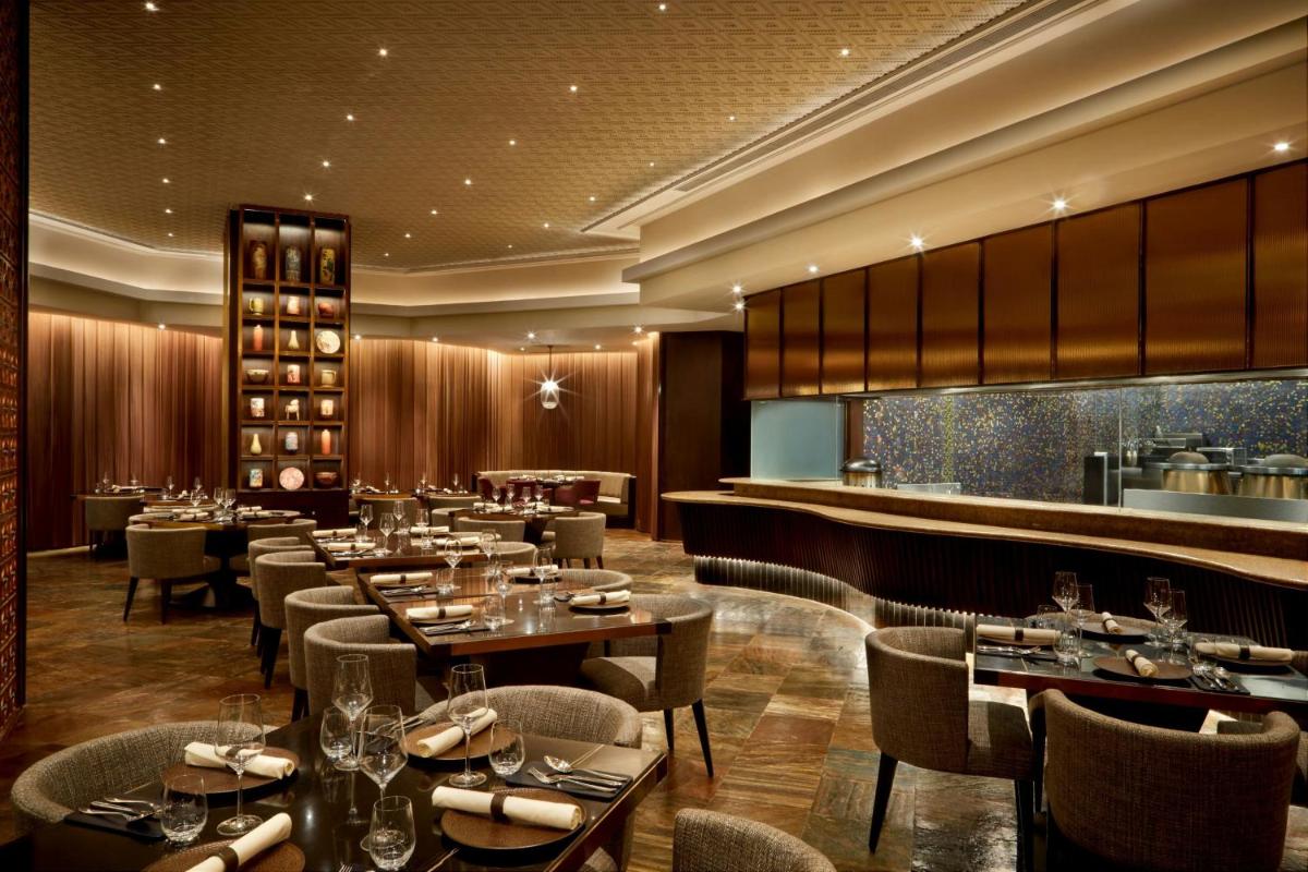 a restaurant with tables and chairs and a bar at JW Marriott Mumbai Juhu in Mumbai
