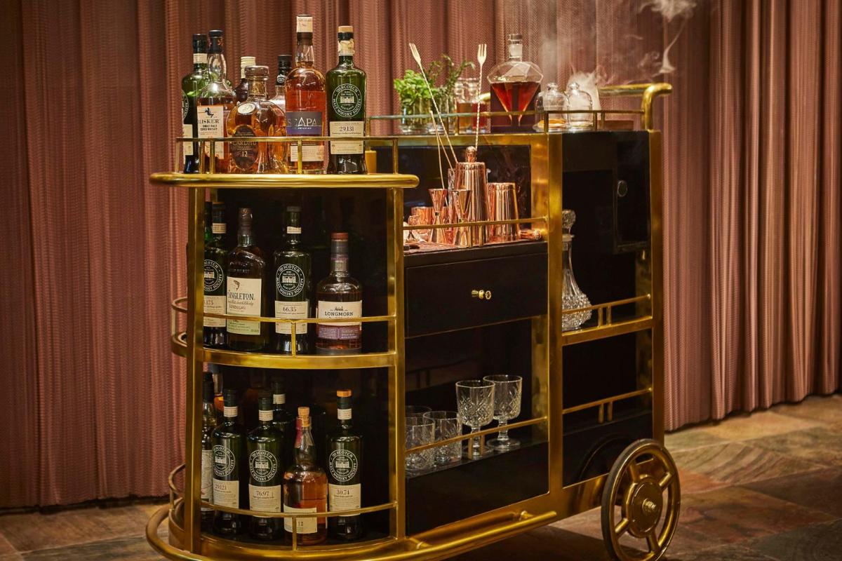 a bar cart filled with lots of bottles of alcohol at JW Marriott Mumbai Juhu in Mumbai