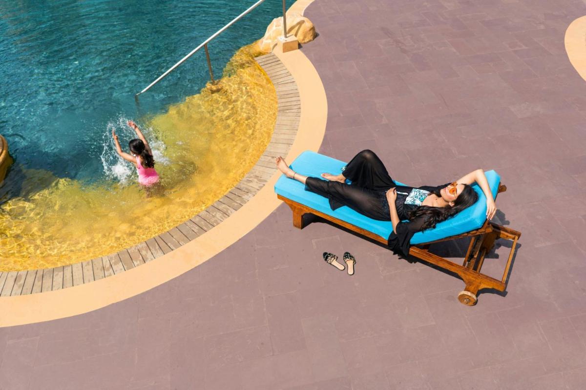 a man and a woman laying on a raft in a pool at JW Marriott Mumbai Juhu in Mumbai