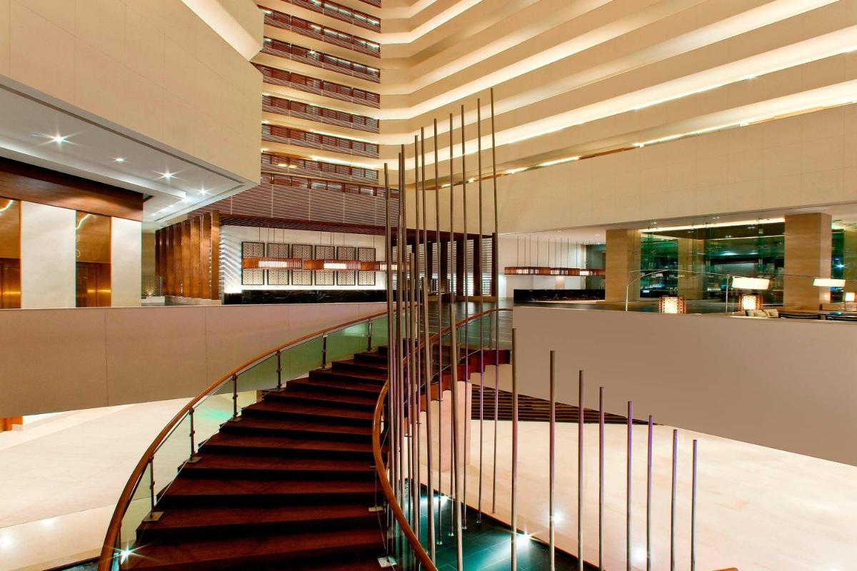 a spiral staircase in a building with a lobby at The Westin Hyderabad Mindspace in Hyderabad