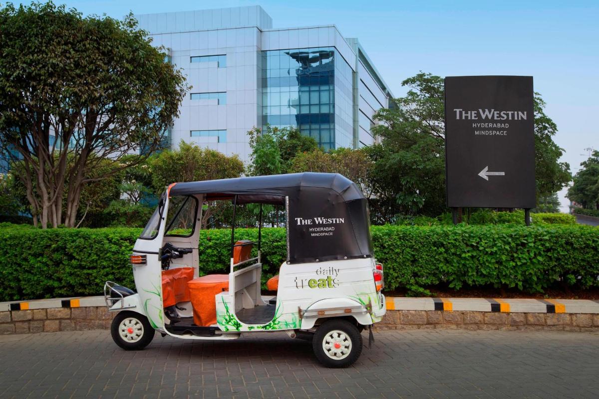 a small golf cart parked in front of a building at The Westin Hyderabad Mindspace in Hyderabad