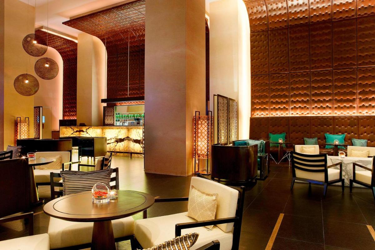 a dining room with tables and chairs in a restaurant at The Westin Hyderabad Mindspace in Hyderabad