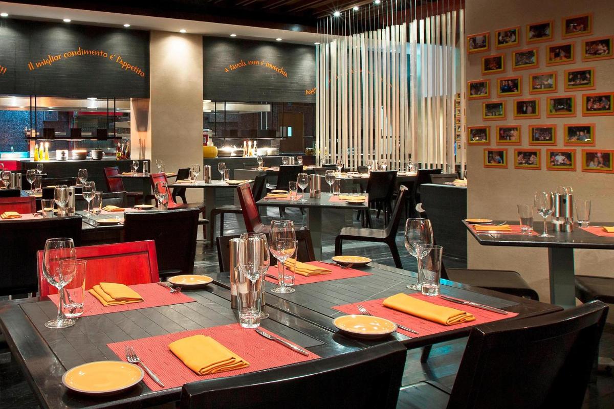 a dining room with a table with yellow napkins and glasses at The Westin Hyderabad Mindspace in Hyderabad
